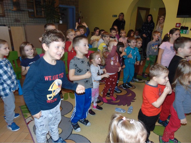 Grupa przedszkolaków na sali biorąca udział w zabawie ruchowej